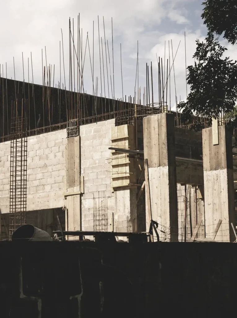 Chantier de construction avec murs en béton et armatures métalliques apparentes