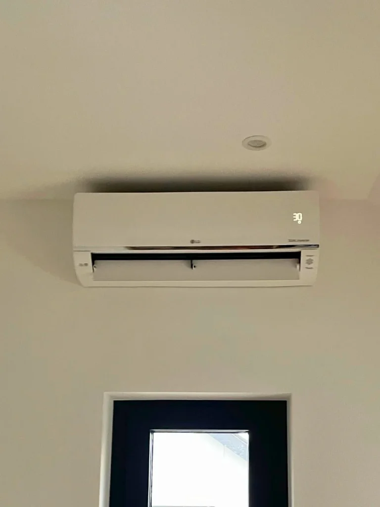 Climatiseur mural discret installé en hauteur dans une pièce